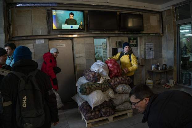 Menekülők hallgatják Zelenszkij tévébeszédét Lvivben