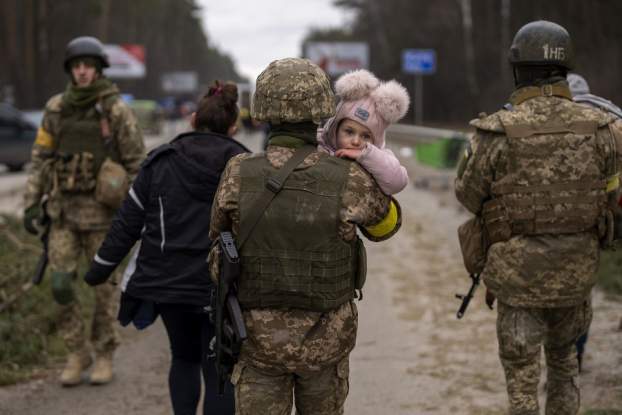 Az ukrán katonák segítenek a civil lakosságnak a menekülésben