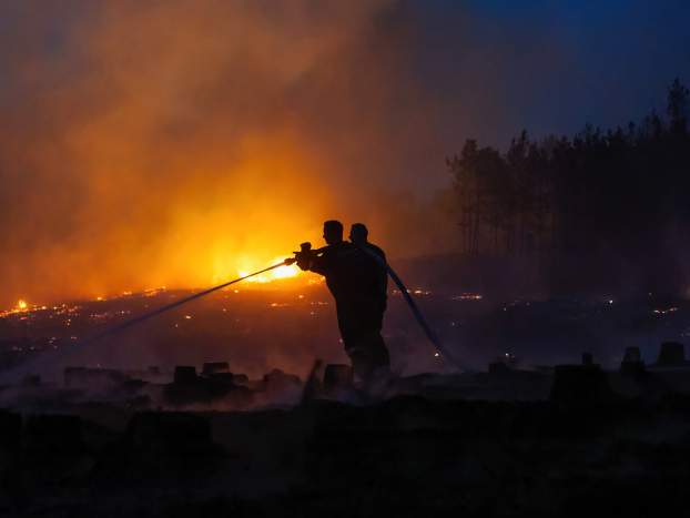 Tűzoltók oltják 2022. július 13-án az Izsák és Soltszentimre közötti erdőben délután keletkezett tüzet