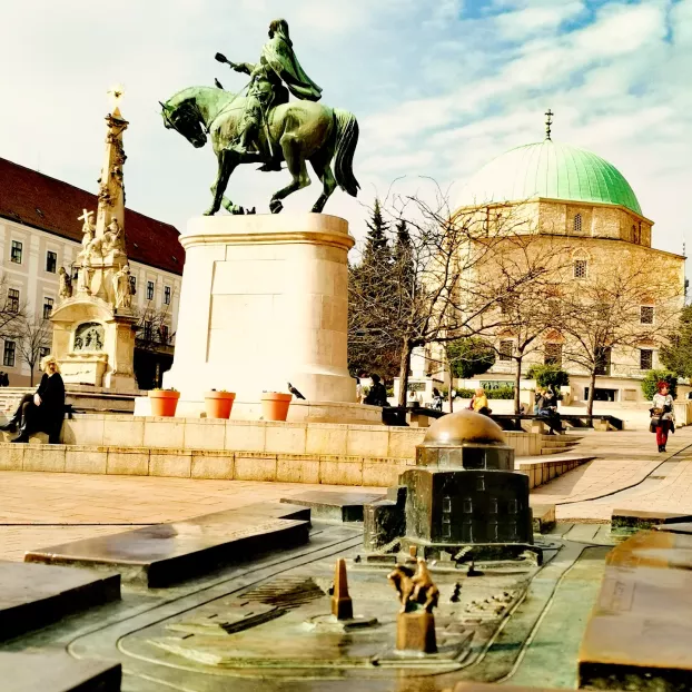A Hunyadi-szobor, a Szentháromság-szobor és a dzsámi a Széchenyi téren Pécsen.
