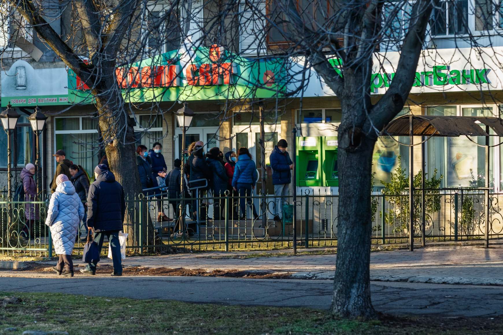 Helyi lakosok állnak sorban pénzfelvételért az ukrán Privat Bank egyik fiókjánál található ATM-nél Ungváron