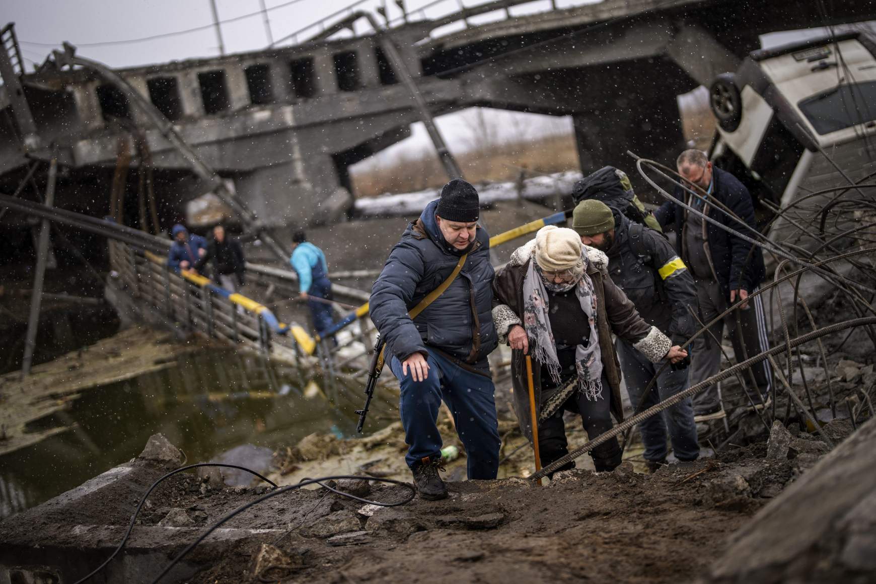 Milicista segít idős menekülőknek Kijevben, a felvétel március 2-án készült