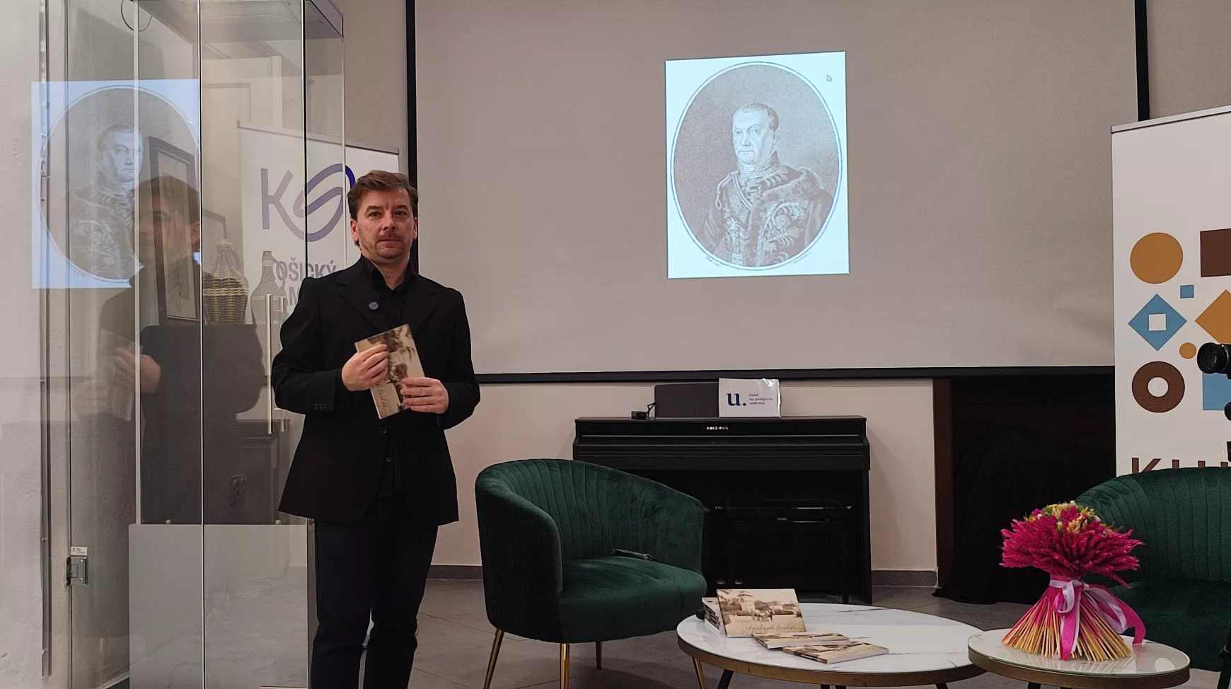 Cap György helytörténész, háttérben a lipicai ménesalapító gróf Mailáth III.József.