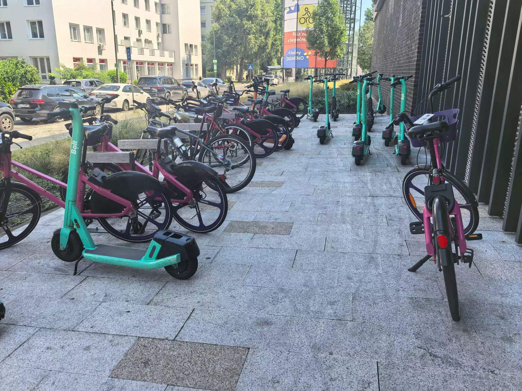 Elektromos rollerek és bérelhető kerékpárok a pozsonyi buszpályaudvar melletti bicikli parkolóban - 2025